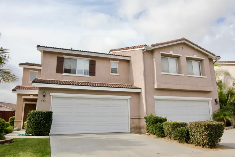 A sunny day in the area of Ivey Pointe, garage, bushes, palm trees, condos