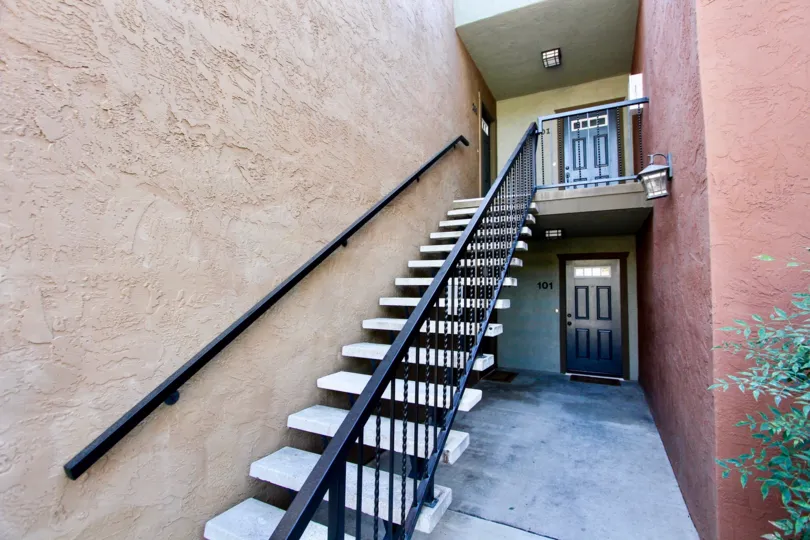 Two story red housing units with black doors at the La Estancia in Oceanside CA
