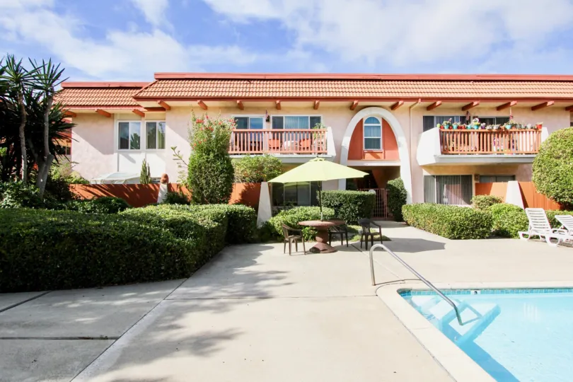The pool at La Montana apartment complex showing deck furniture and landscaping on a sunny day.