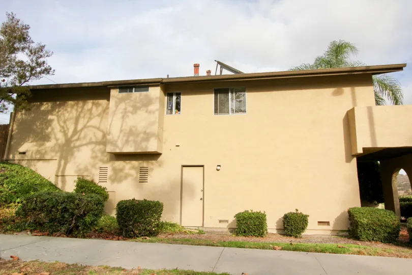 A tan painted building is on the corner of a community in the Lake Village area.