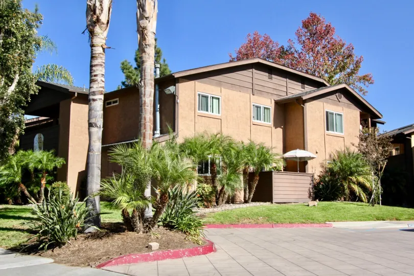 A sunny day with trees by a unit of Lakeshore Villas in Oceanside, California