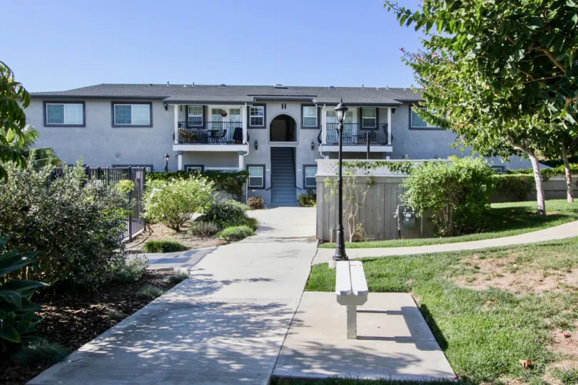 Building H with green lawn and bench at Las Brisas in Oceanside, California