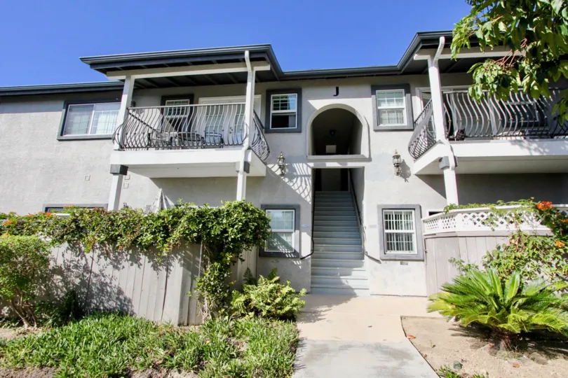 Charming facade sourrounded by lush greenery at Las Brisas in Oceanside, California.