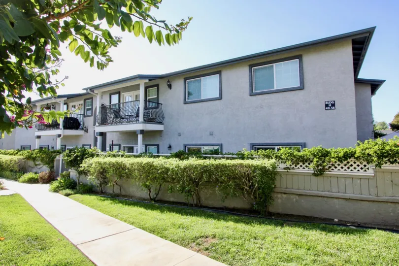 Condo row houses in Las Brisas with attractive landscaping, fencing, and trees