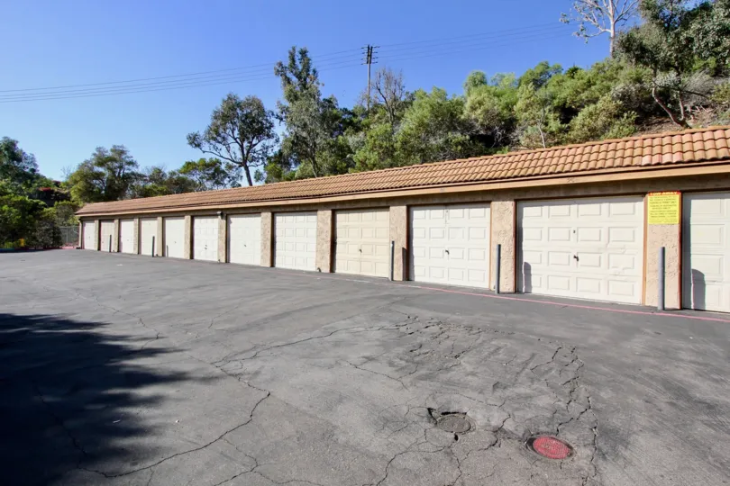 A sunny day in the area of Loma Alta Village, outside, parking lot, garages, trees