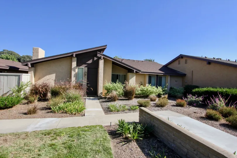 A big house with a landscaped yard in the Los Arbolitos community