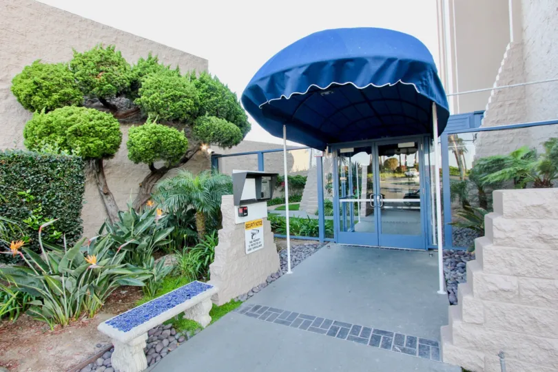 Walkway with a blue canopy near buildings at Marina Towers in Oceanside CA