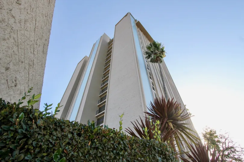A view from the foot of Marina Towers in Oceanside, CA, with bushes and trees