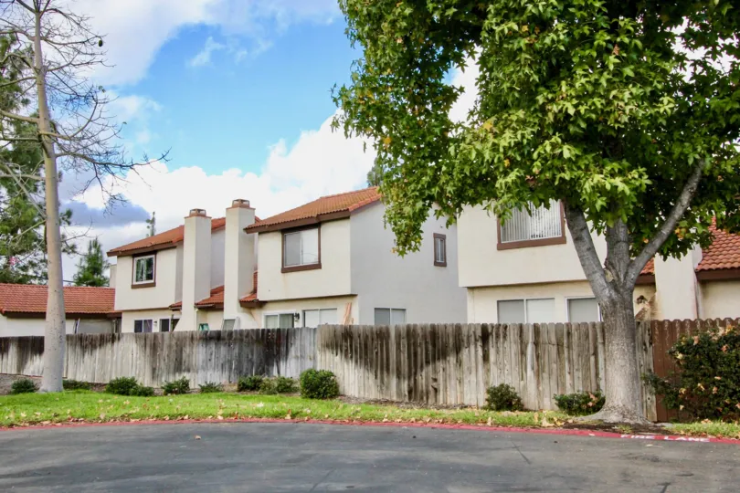 A stained wood privacy fence surrounds the Mission Meadows townhomes