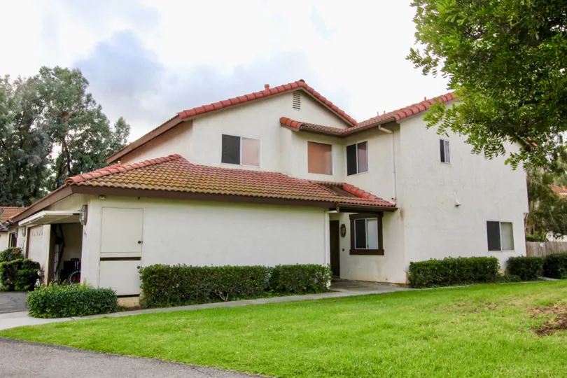 A sunny day in the area of Mission Meadows, outside, grass, yard, bushes. garage. bike