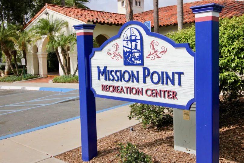 Beautiful white and blue housing with lots of green foliage at Mission Pointe Townhomes