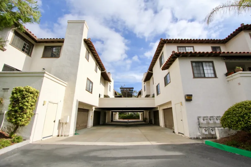 A sunny day in the area of Mission Point Townhomes, outside, driveway, garage, balcony, bushes