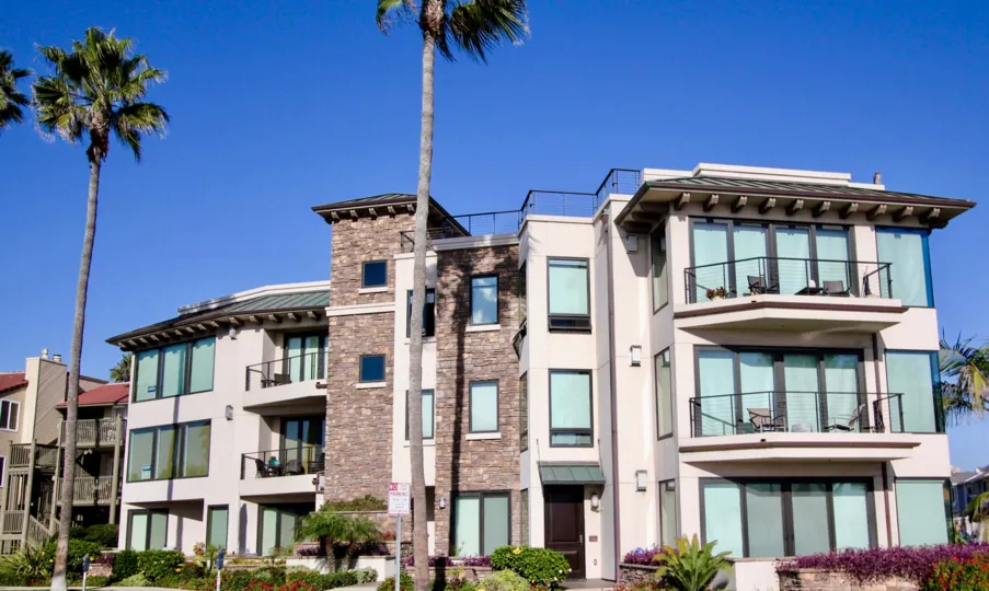 Three story building with brick and glass walls at Montego Condominiums in Oceanside CA