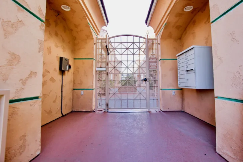 A sunny day in the area of Neptune Point, outside, gated entrance, buzzer, mailboxes