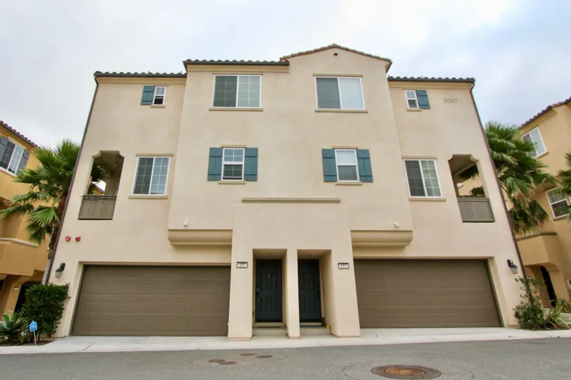 A duplex with garages and trees at North River Village in Oceanside, CA