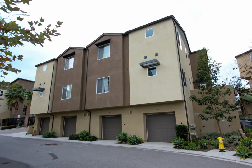 Beige and Tan large unit housing at North River Village with Attached garages