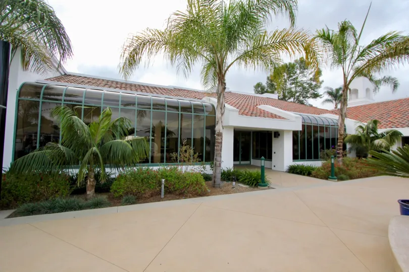 In the Ocean Hills Country Club communtity a small building has palm trees in front.