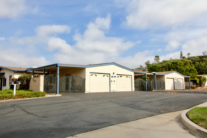 An exterior view of the Oceana Mission homes with garage and private gated carports from the street.