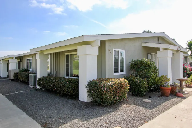 Single story gray and white home surrounded by plants in the Oceana South community in Oceanside CA