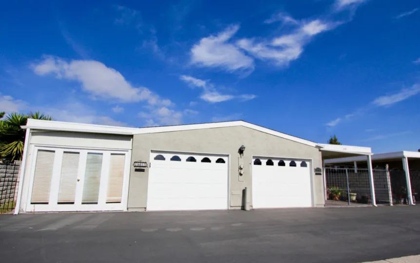 A sunny day in the area of Oceana South, outside, driveway, garage, tree, clouds
