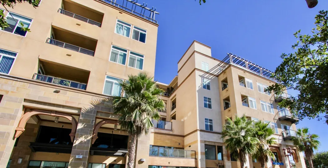 A high building sitting in the sun and surrounded by palm trees in Oceanside, California