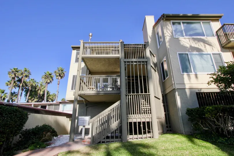 An exterior view of the Pacific Star Pine apartment homes showing the community mailbox, exterior staircase, and balconies.