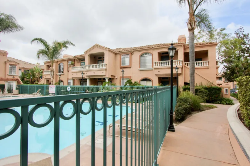 Swimming pool surrounded by a blue fence at Palmill Del Oro in Oceanside CA