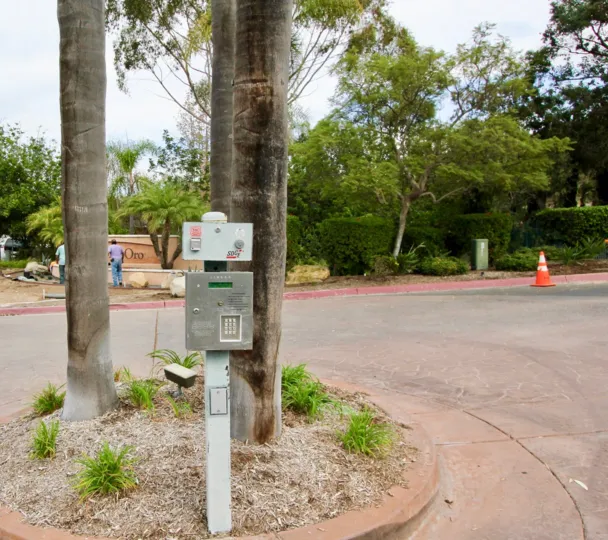 A sunny day in the area of Palmilla Del Oro, street, traffic cone, phone box, people, tree