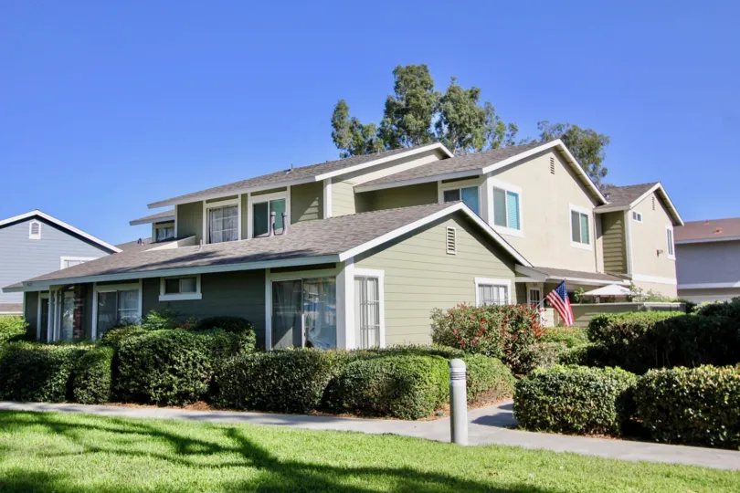 beautiful large white house with lots of green shrubs.
