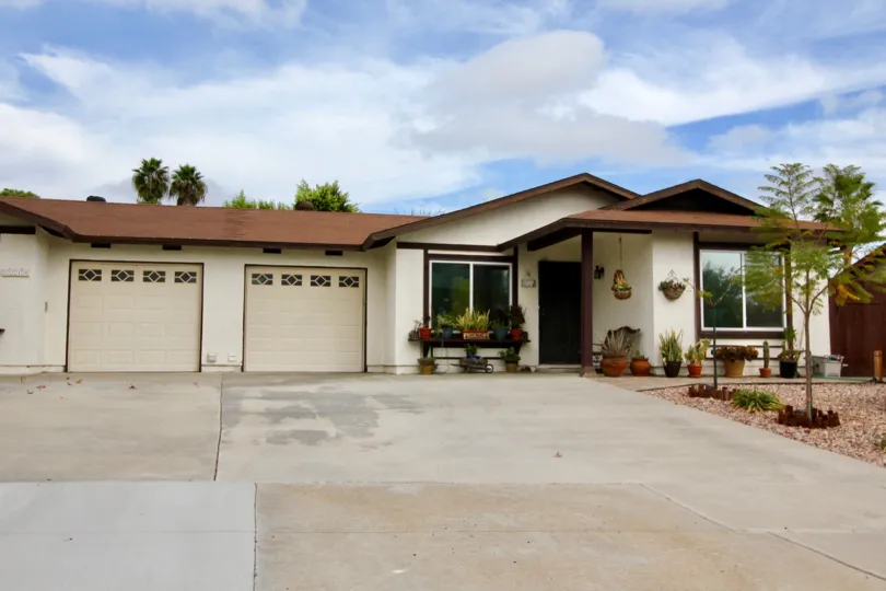 Two brown doors on a single home at the end of a driveway inside Peacock Hills at Oceanside CA