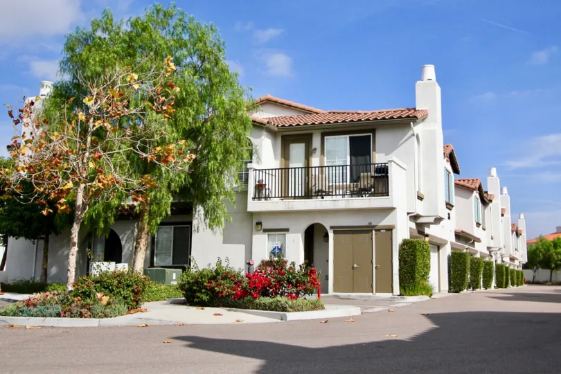 Mediterranean-style apartment complex with well trimmed hedges