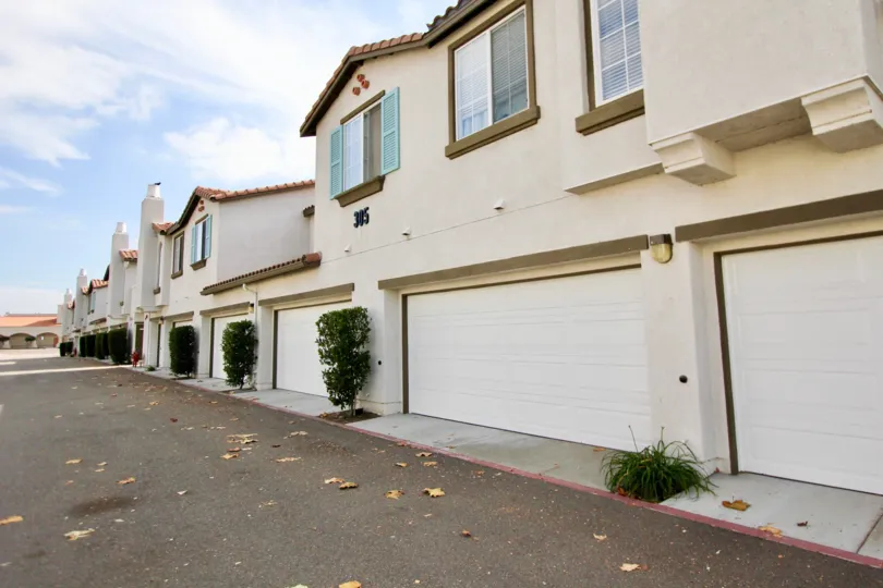 Bushes sit in front of pillars on townhomes at Pelican Cove