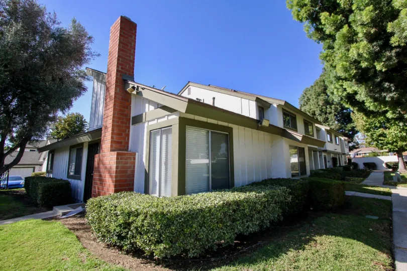 Red brick chimney on the side of a residence inside Pepperwood Villas at Oceanside CA