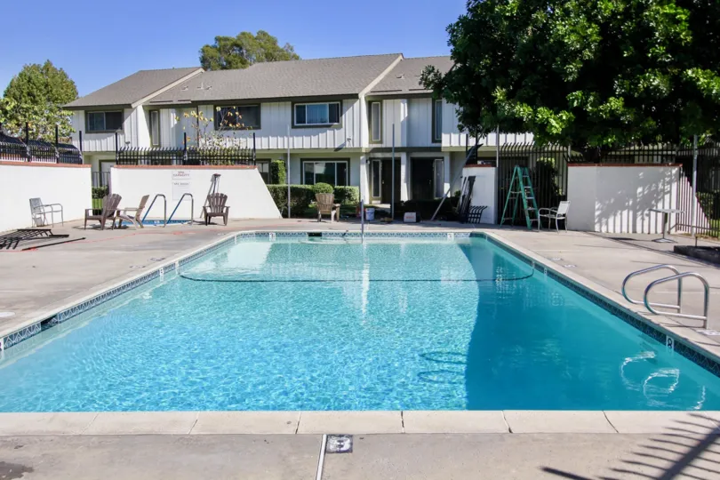 Large swimming pool surrounded by white walls in Oceanside Ca at pepperwood Villas