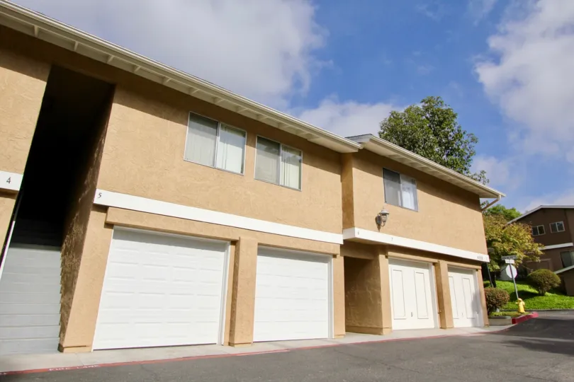 Two story brown condos with white garage doors inside Quail Ridge in Oceanside CA
