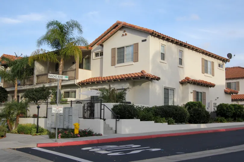 A sunny day in Rancho Rose with apartments and palm trees.