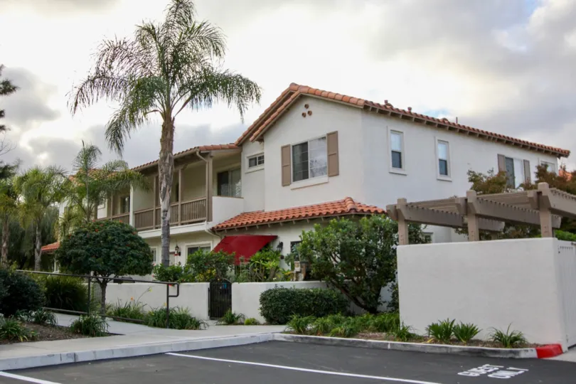 A sunny day in the area of Rancho Rose, outside, parking lot, palm tree, balcony, walkway