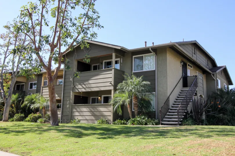 Two story condominiums with a tall tree out front in Oceanside CA at River Trail