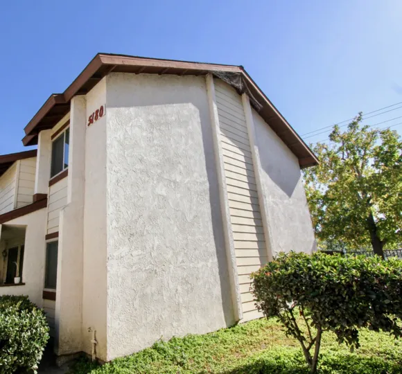 Two story white building with a brown roof inside Riverview Townhomes at Oceanside CA
