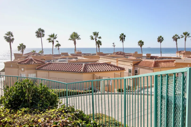 A sunny day in the area of San Miguel III, ocean view, palm trees, rooftops, fence, bushes