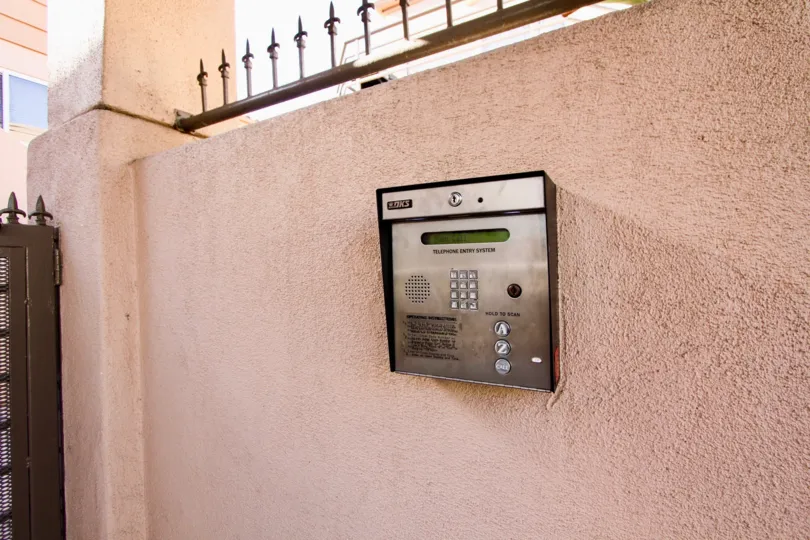 A callbox sits on a tan wall outside the San Miguel III condos