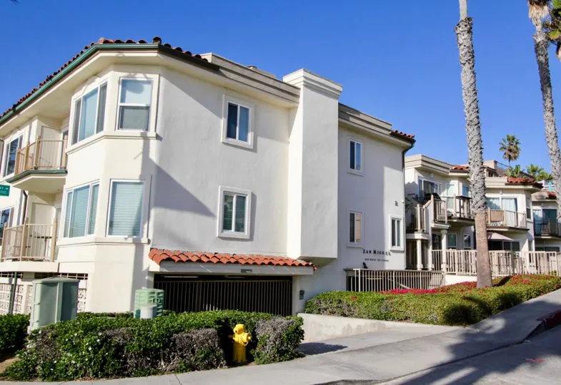 Condominium complex with gated parking and professional landscaping with palm trees in San Miguel, Oceanside, CA