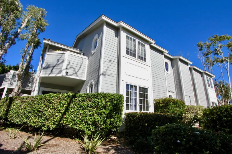 Side view of a huge building and shrubs in the garden in Sandpiper Cove.
