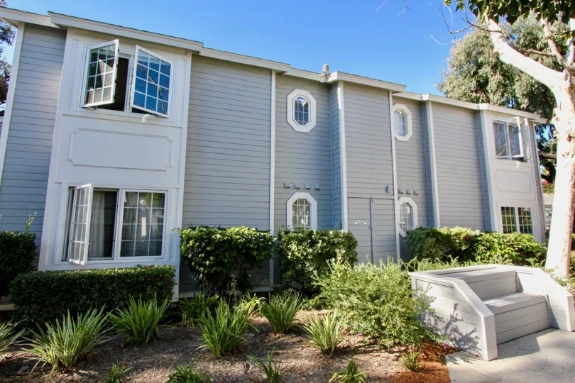 Beautiful grey house with green foliage located at Sandpiper Cove