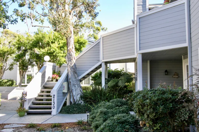 THE HOUSE IN THE SANDPIPER COVE WITH THE STEPS, TREES, PLANTS.