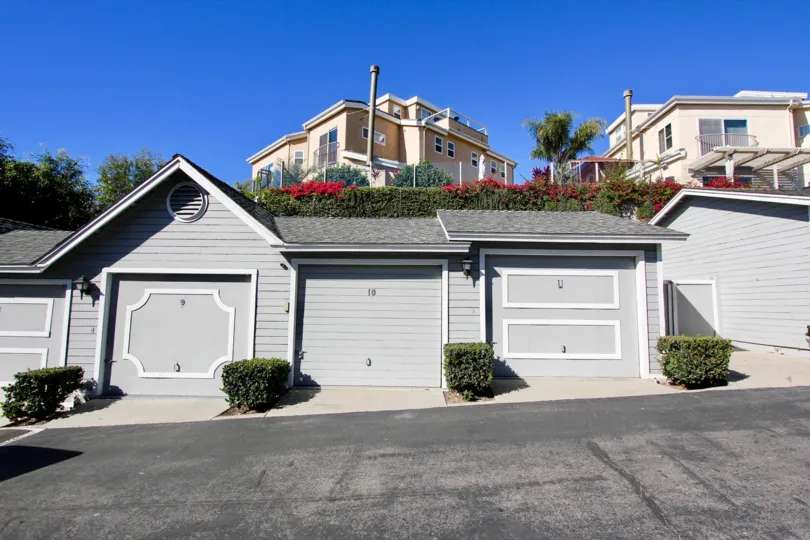 Attached vinyl-sided attached garages on a backlane in the community of Sandpiper Cove, Oceanside, CA