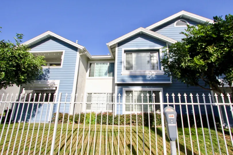 Light blue, two-story house with white fence in the community of Sea Village, located in Oceanside, California
