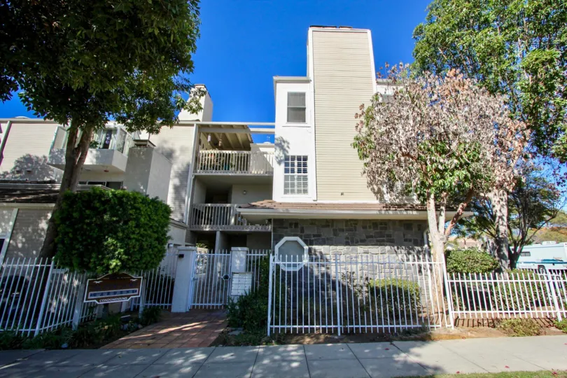 front entrance decorated trees and plants and building covered with white paint gate in Silver Surf Gardens
