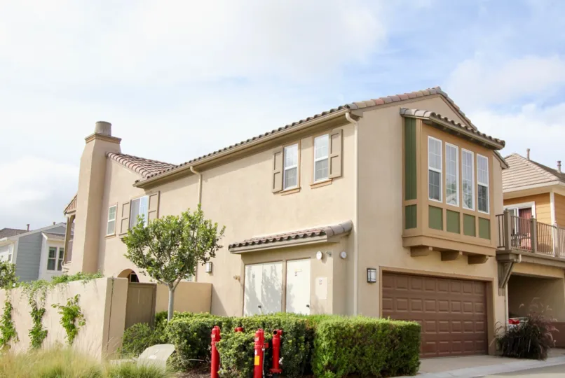 Two story brown home with a large garage door n Oceanside CA at St Cloud at Ocean Ranch