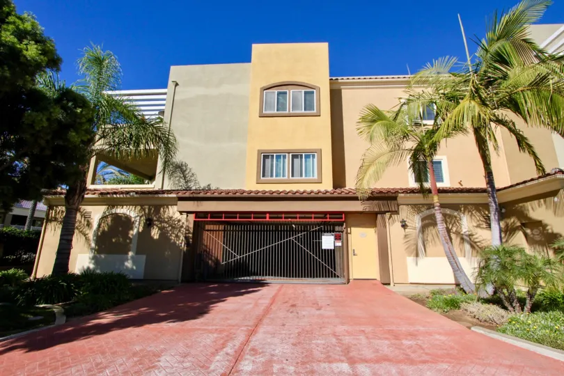 Private gates and palm tree lined drive of beautiful Summit Village.
